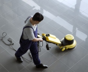 Pracownik myje podłogę odkurzaczem przemysłowym